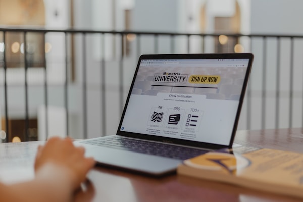 person using macbook pro on brown wooden table
